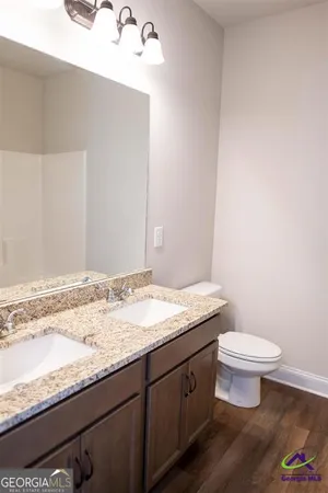 a bathroom with a granite countertop sink a toilet and a mirror