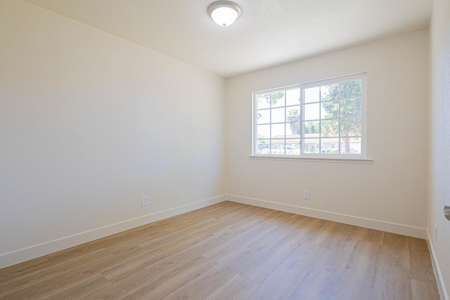 17925 Rodeo Drive Madera, CA 93638 - Photo 12 of 26 an empty room with wooden floor and windows