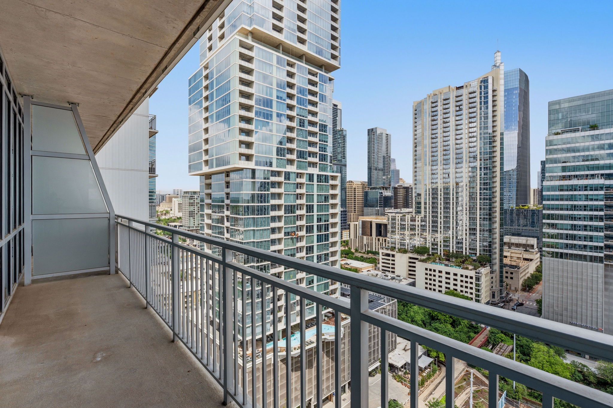 222 West Avenue, Unit 2207 Austin, TX 78701 - Photo 12 of 30 Private balcony with concrete flooring and metal railing, offering expansive urban skyline