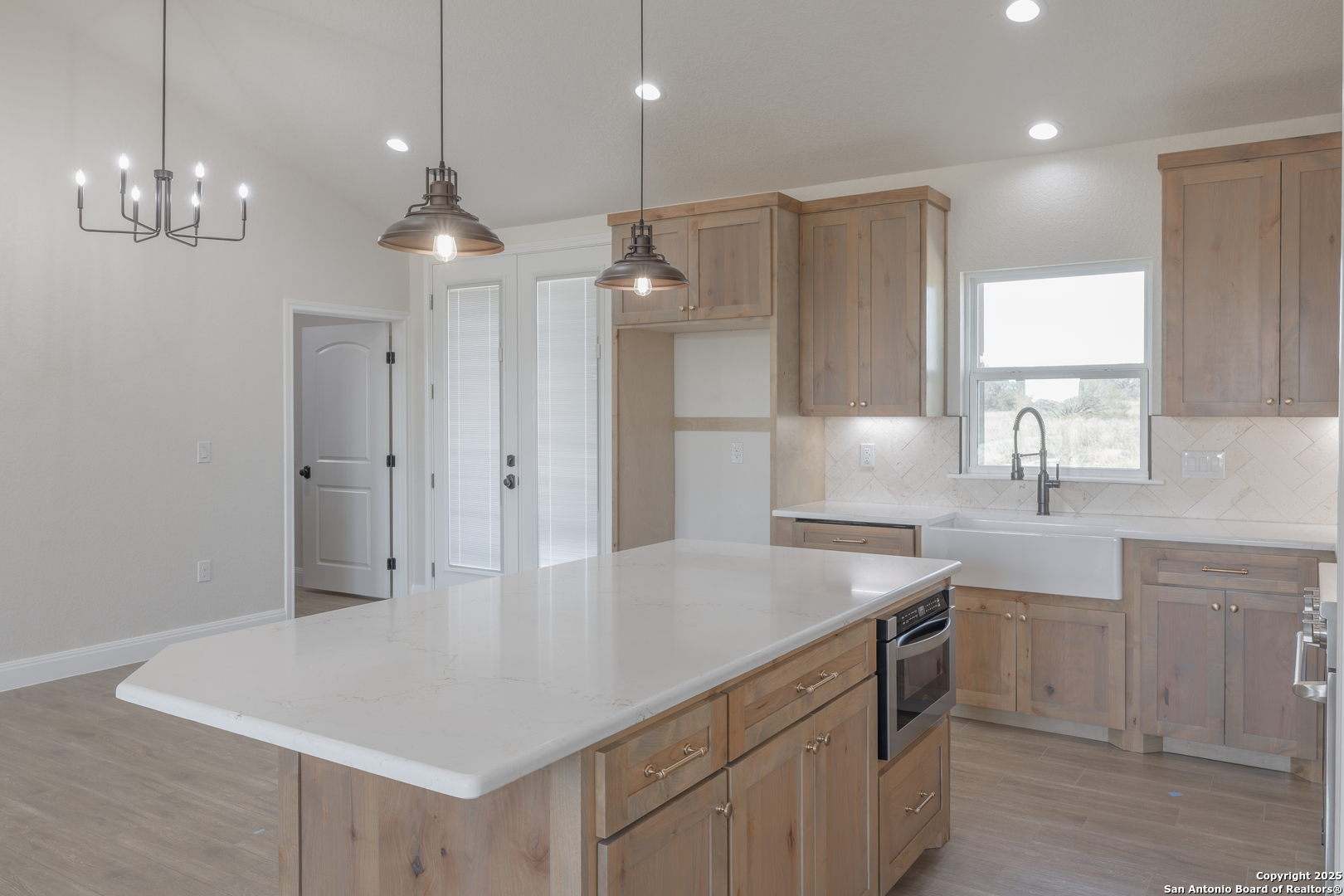 591 Eichman Road Poteet, TX 78065 - Photo 8 of 18 a kitchen with a white center island a stove a refrigerator cabinets and wooden floor