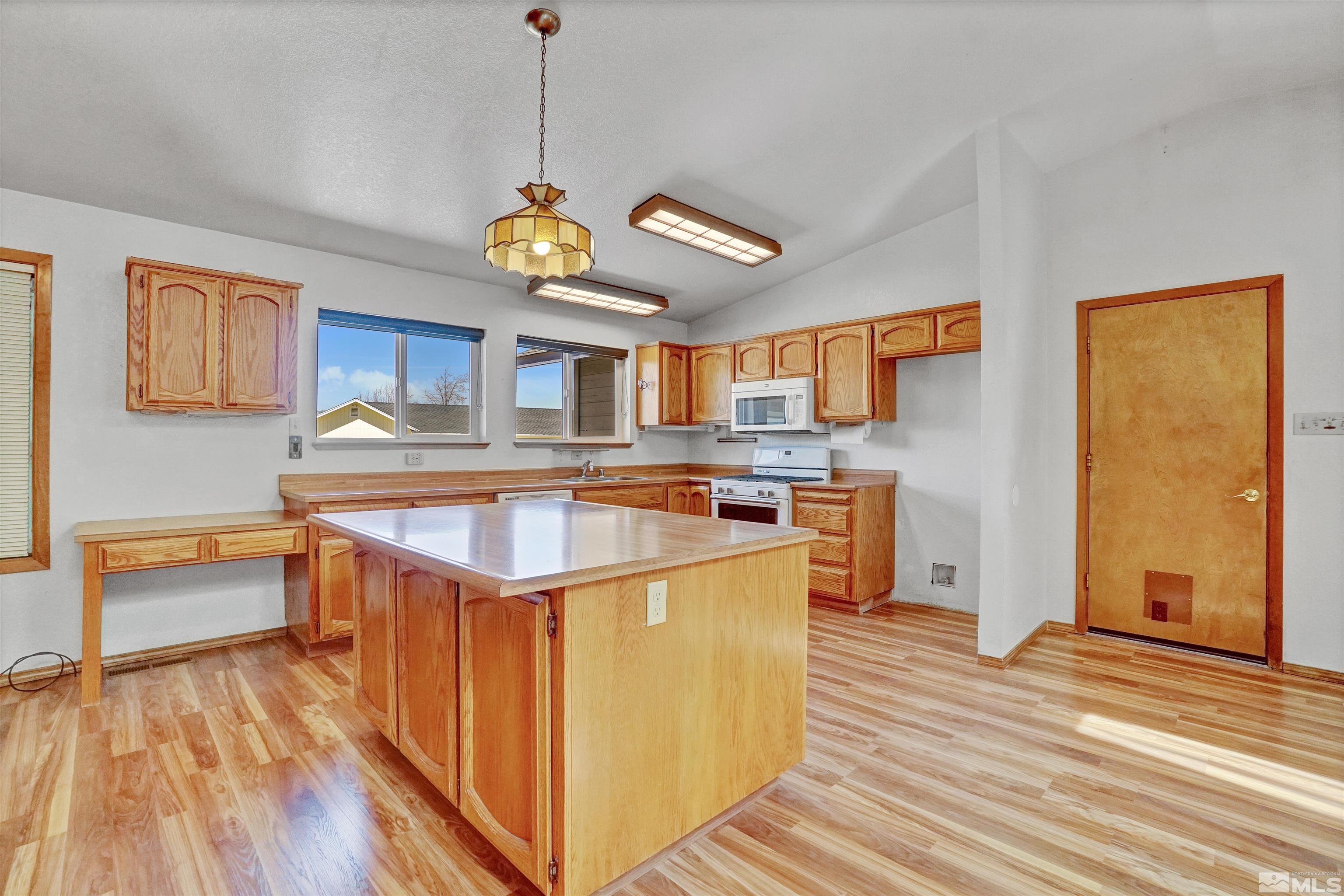 725 Addler Road Gardnerville, NV 89460 - Photo 12 of 24 a kitchen with stainless steel appliances granite countertop a sink a stove a refrigerator cabinets and wooden floor