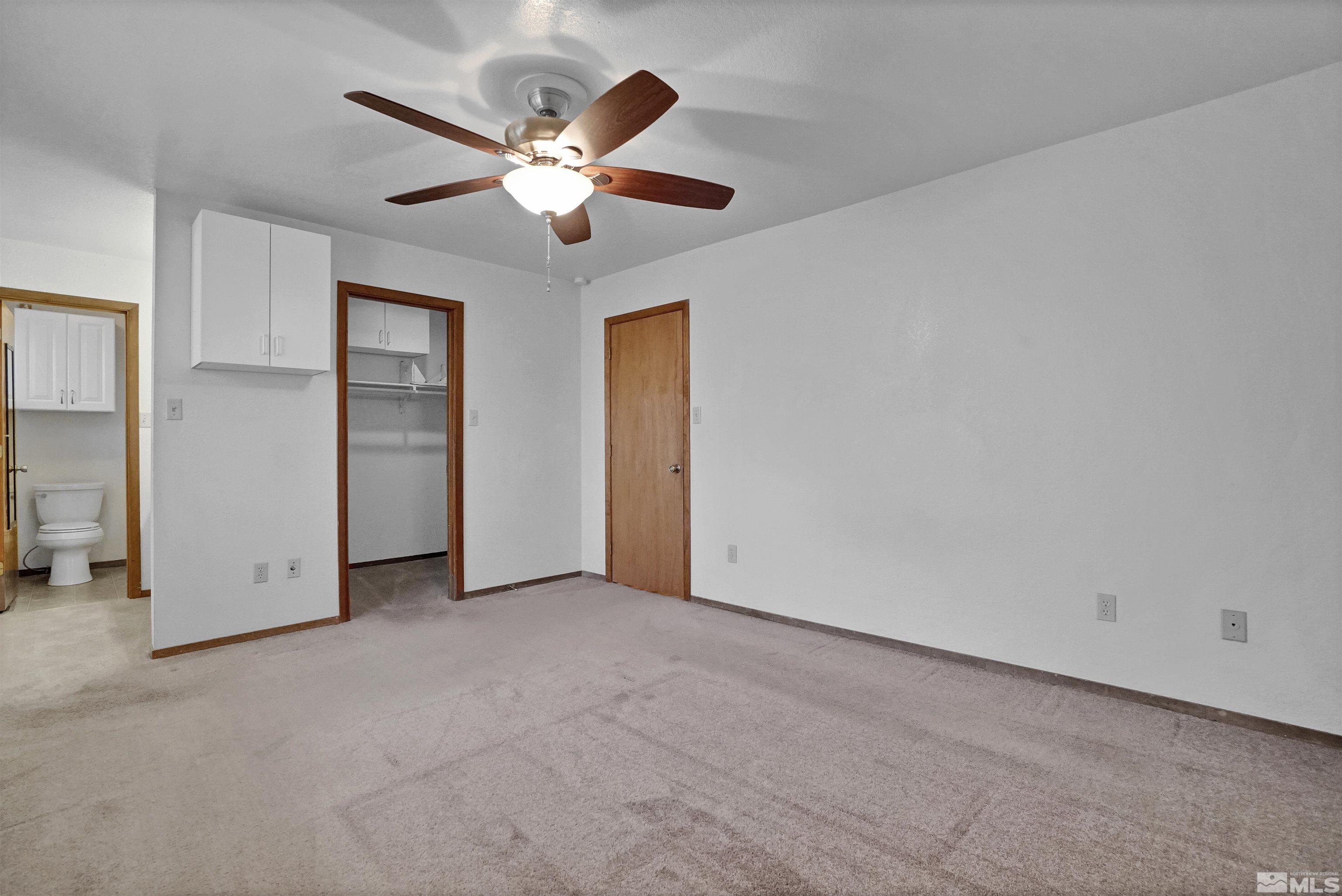725 Addler Road Gardnerville, NV 89460 - Photo 15 of 24 an empty room with closet and a chandelier fan