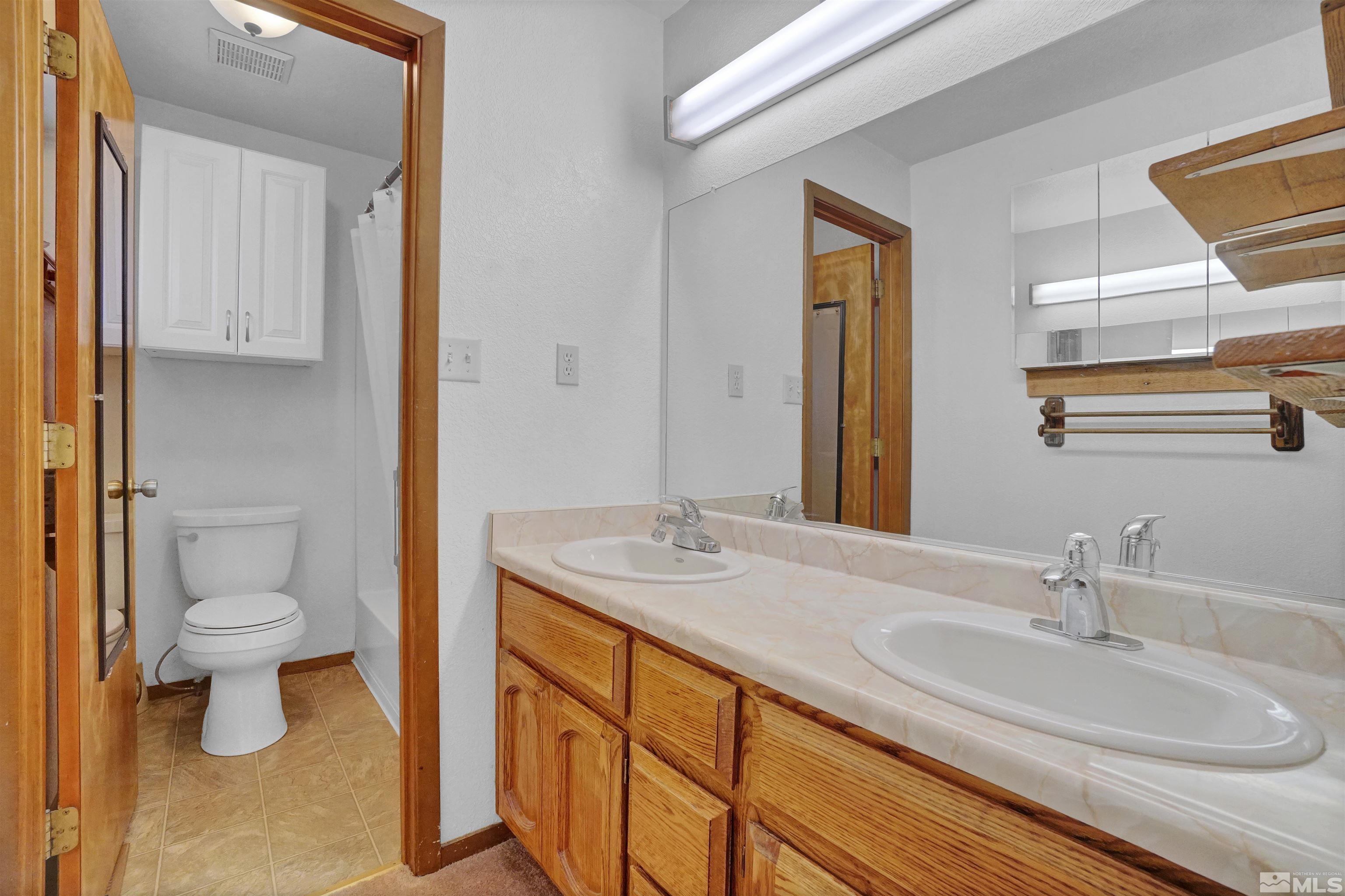 725 Addler Road Gardnerville, NV 89460 - Photo 16 of 24 a bathroom with a granite countertop sink toilet and mirror