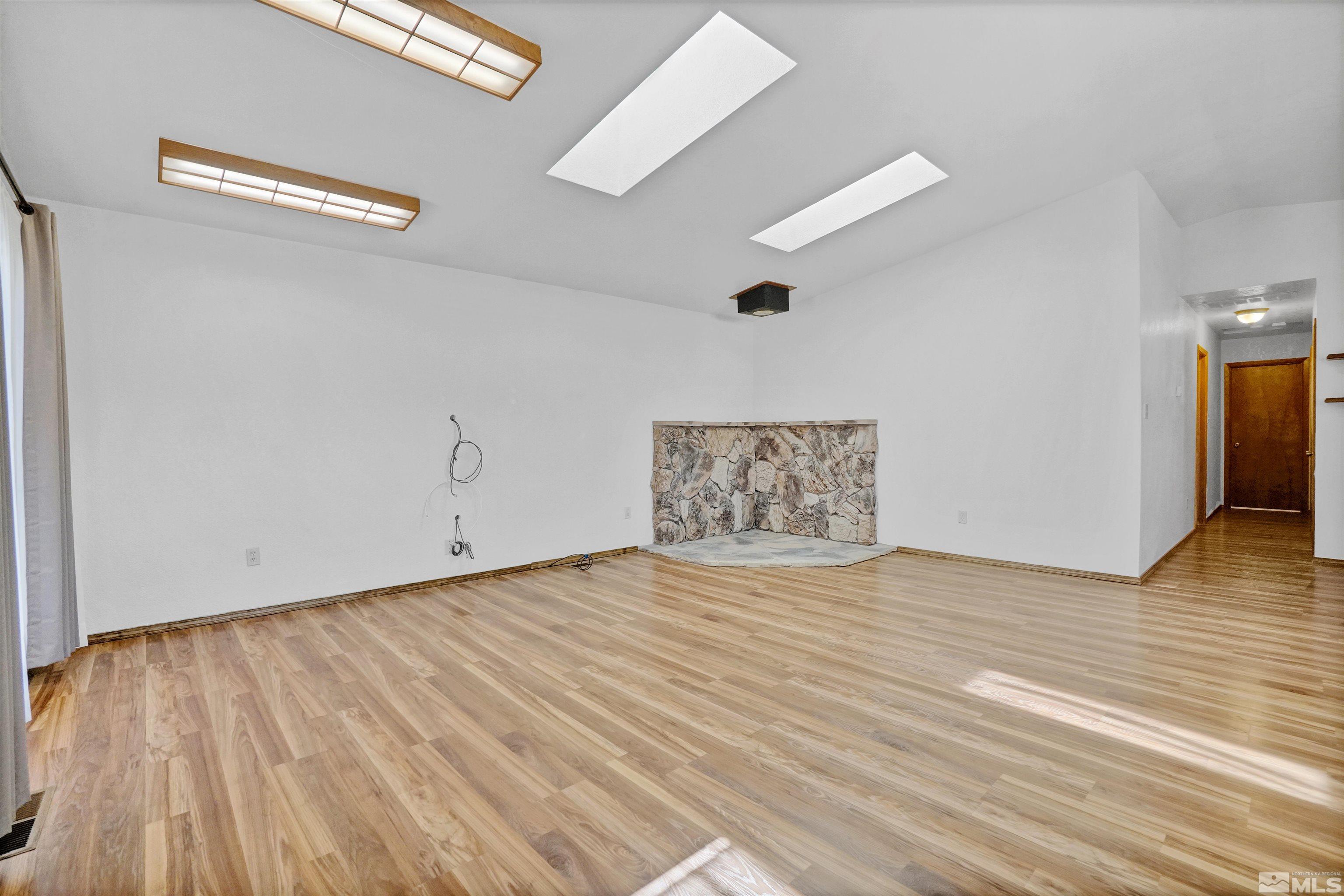 725 Addler Road Gardnerville, NV 89460 - Photo 7 of 24 an empty room with wooden floor and windows
