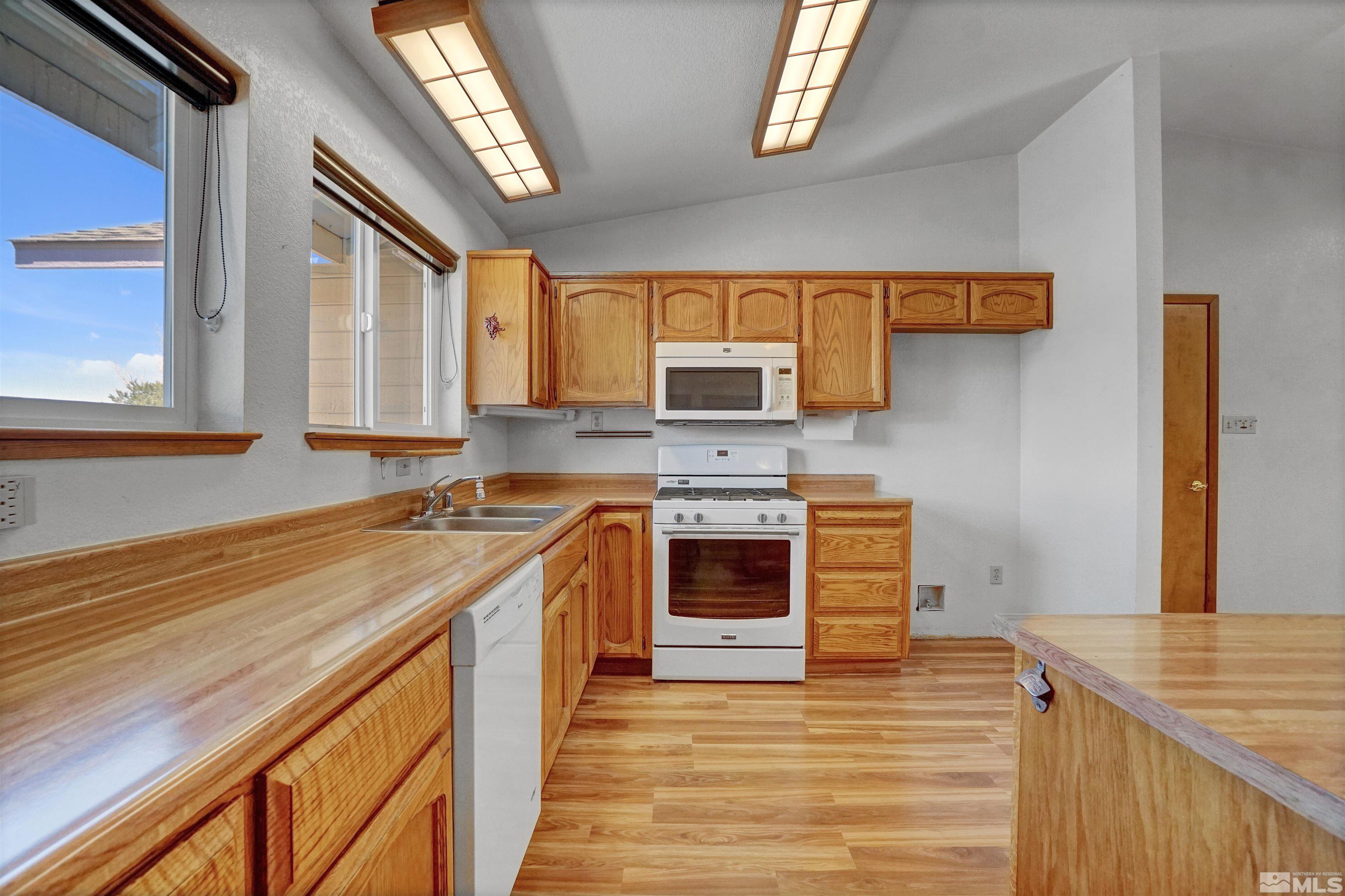725 Addler Road Gardnerville, NV 89460 - Photo 9 of 24 a kitchen with stainless steel appliances granite countertop a sink stove and refrigerator