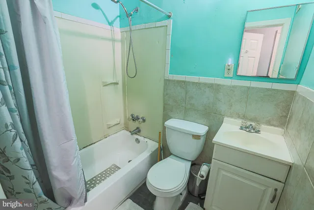 a white toilet sitting next to a bathroom sink and a shower