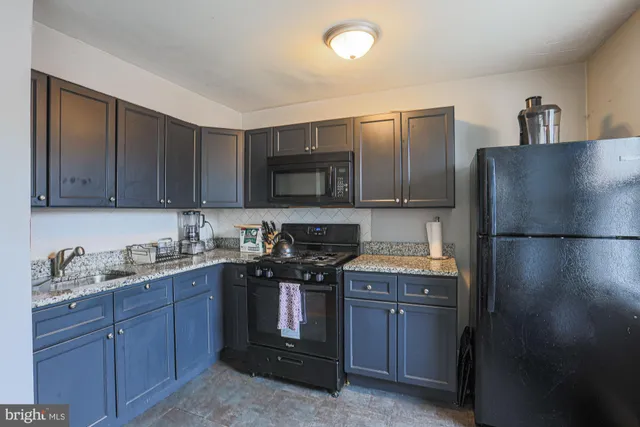 a kitchen with stainless steel appliances granite countertop a refrigerator and a stove top oven