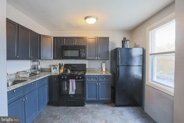 a kitchen with sink a refrigerator and cabinets