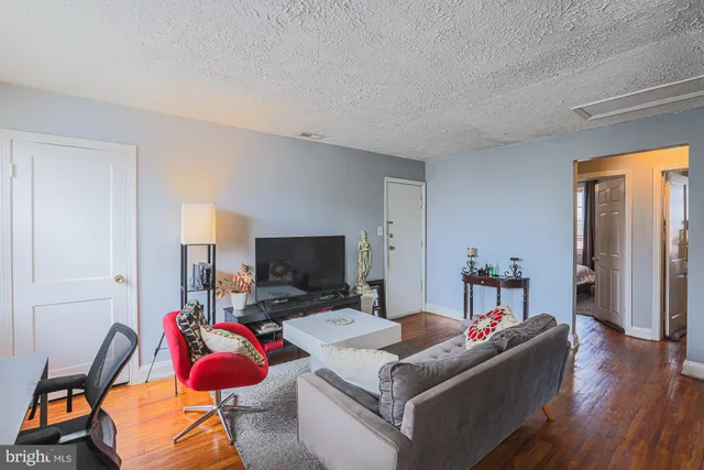a living room with furniture a flat screen tv and a window