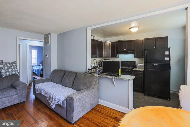 a living room with a couch and a view of kitchen