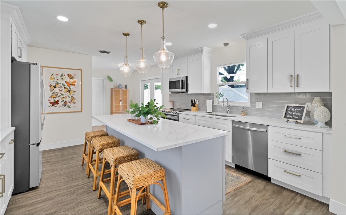 7989 143rd Street Sebastian, FL 32958 - Photo 8 of 30 a kitchen with stainless steel appliances kitchen island a white cabinets and couches