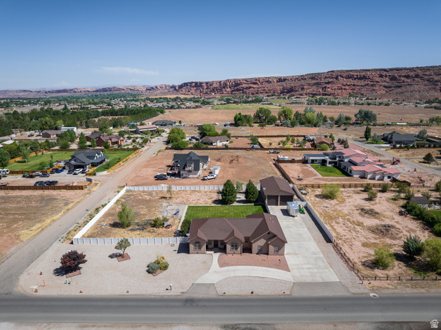 4635 East Sunny Acres Lane Moab, UT 84532 - Photo 7 of 56 Expansive aerial perspective showcasing a residential property with a multi-car driveway, a detached garage structure, and a green lawn