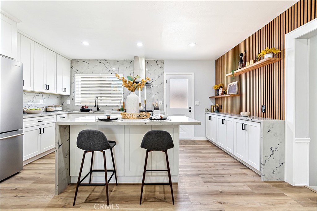 12748 Paramount Boulevard Downey, CA 90242 - Photo 12 of 72 a kitchen with granite countertop white cabinets and stainless steel appliances