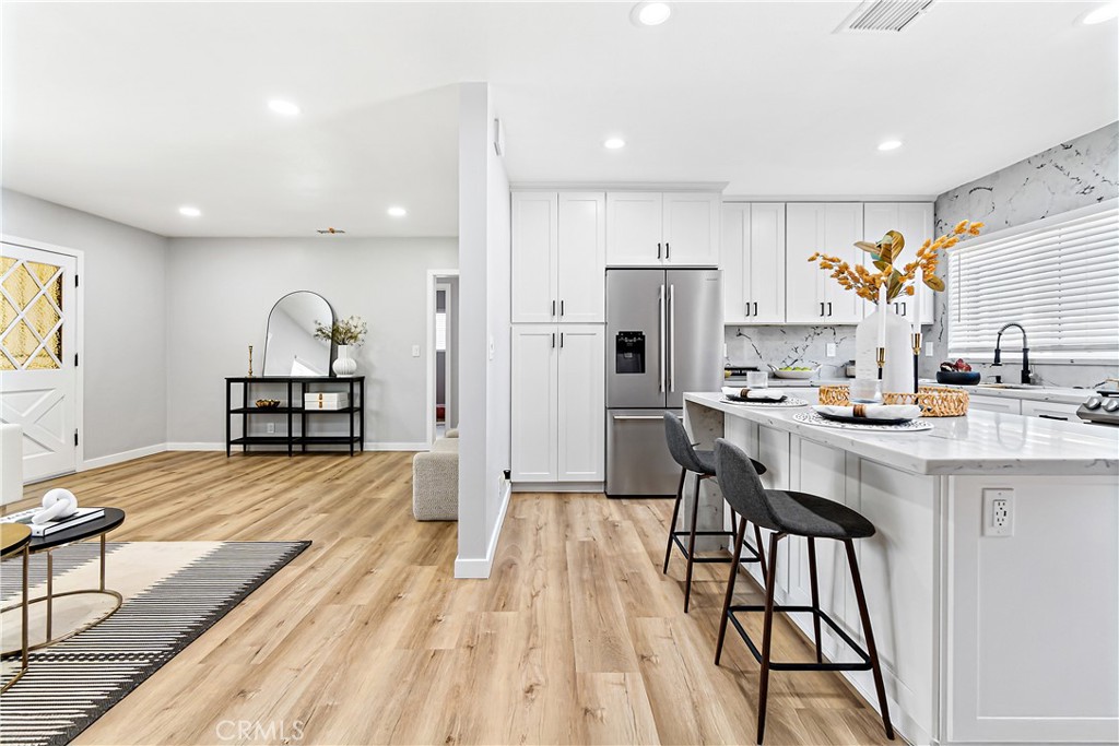 12748 Paramount Boulevard Downey, CA 90242 - Photo 15 of 72 a open kitchen with stainless steel appliances granite countertop a refrigerator and a stove top oven with wooden floor