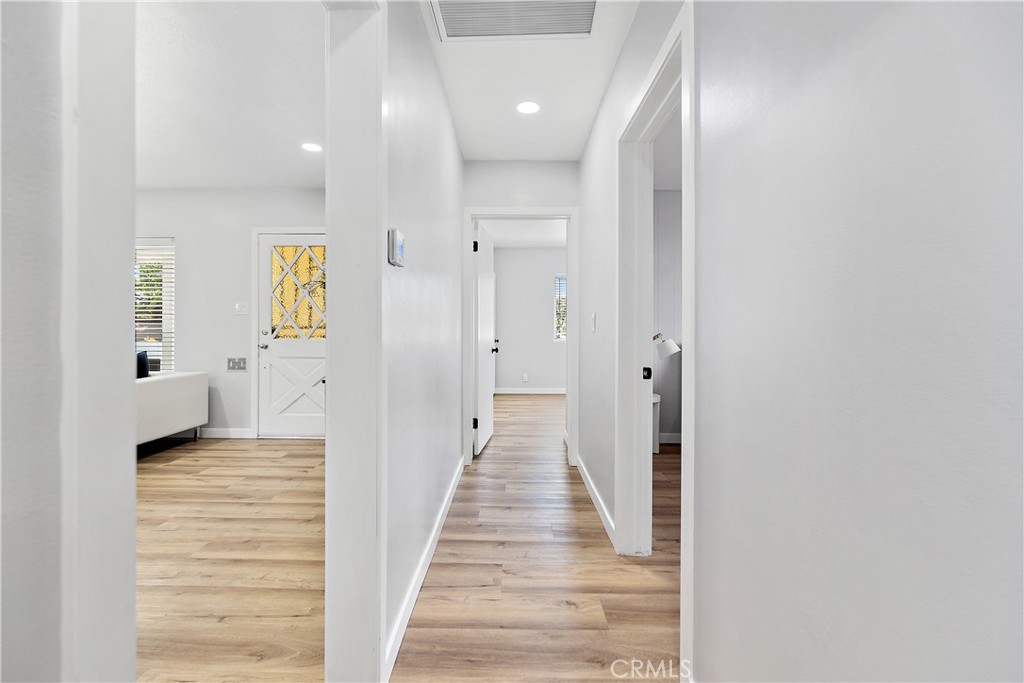 12748 Paramount Boulevard Downey, CA 90242 - Photo 41 of 72 a view of a hallway with wooden floor and a bathroom
