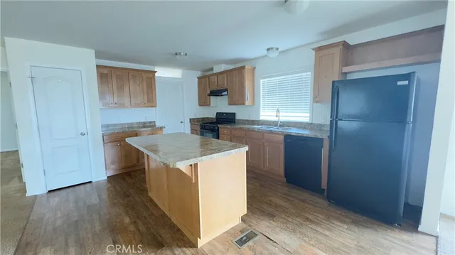 a kitchen with a sink cabinets and wooden floor