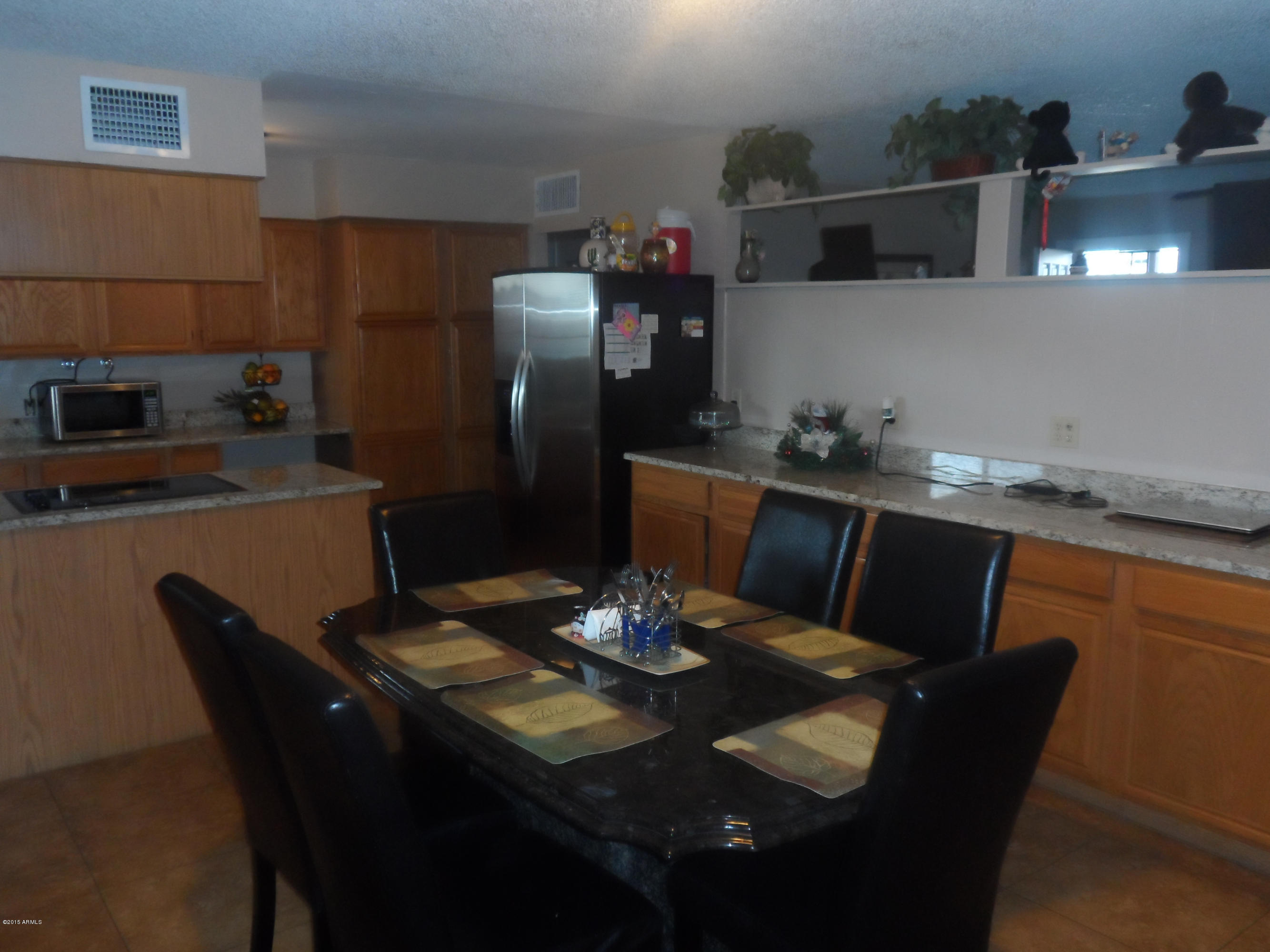 6927 West Camelback Road Phoenix, AZ 85033 - Photo 5 of 23 a kitchen with a table chairs and refrigerator
