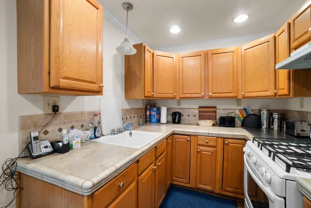 a kitchen with a sink a stove and cabinets