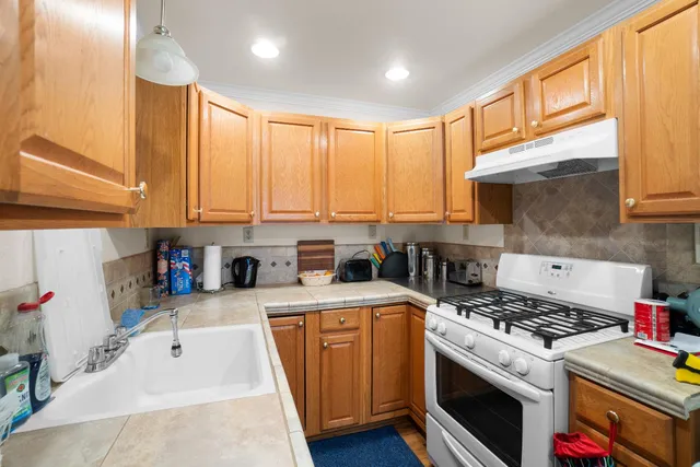 a kitchen with stainless steel appliances granite countertop a stove a sink and a refrigerator