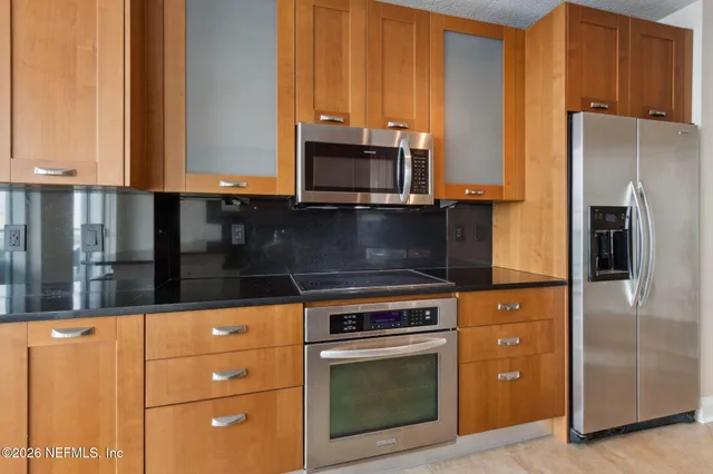 a kitchen with granite countertop cabinets and black appliances