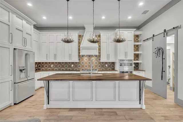 a view of a kitchen with a sink and refrigerator