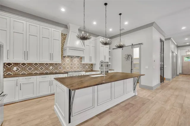 a large kitchen with stainless steel appliances granite countertop a sink a oven and a refrigerator