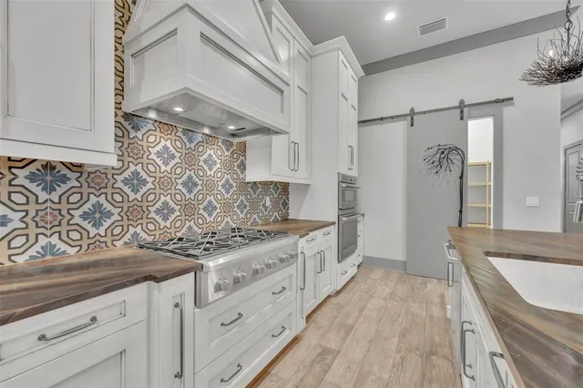 a kitchen with stainless steel appliances granite countertop a lot of counter space and wooden floors