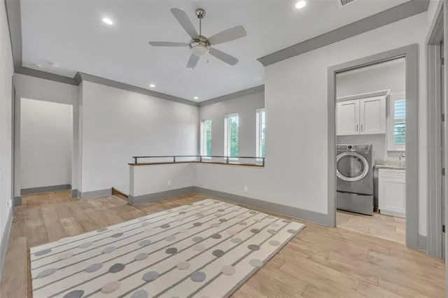 a view of empty room with wooden floor and ceiling fan