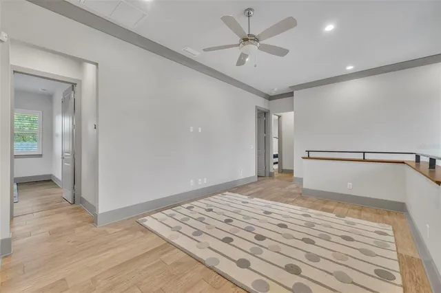 a view of a big room with wooden floor and a ceiling fan