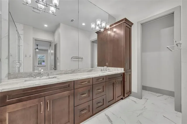 a bathroom with a granite countertop sink a large mirror and a shower
