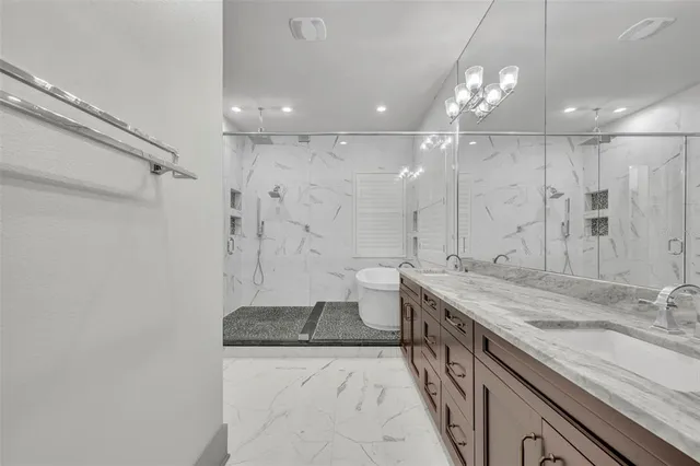 a large bathroom with a granite countertop sink a toilet a shower and a mirror