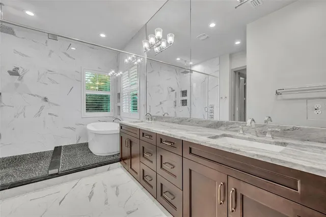 a spacious bathroom with a granite countertop sink a toilet a large mirror and shower