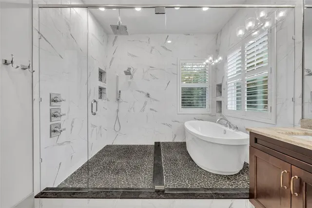 a spacious bathroom with a granite countertop sink a mirror and bathtub