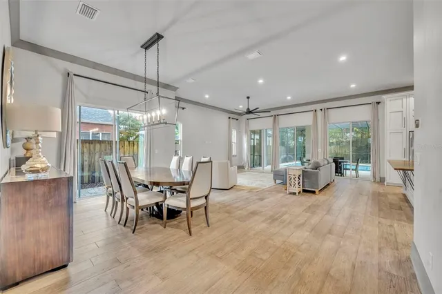 a dining room with furniture a chandelier and wooden floor