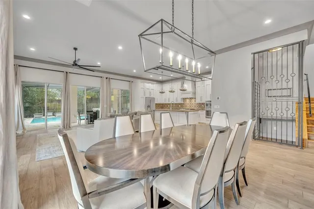 a dining room with furniture a chandelier and wooden floor