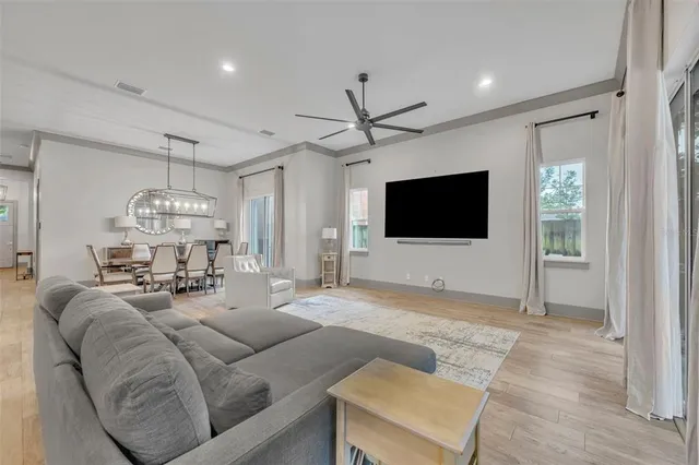 a living room with furniture a flat screen tv and a window