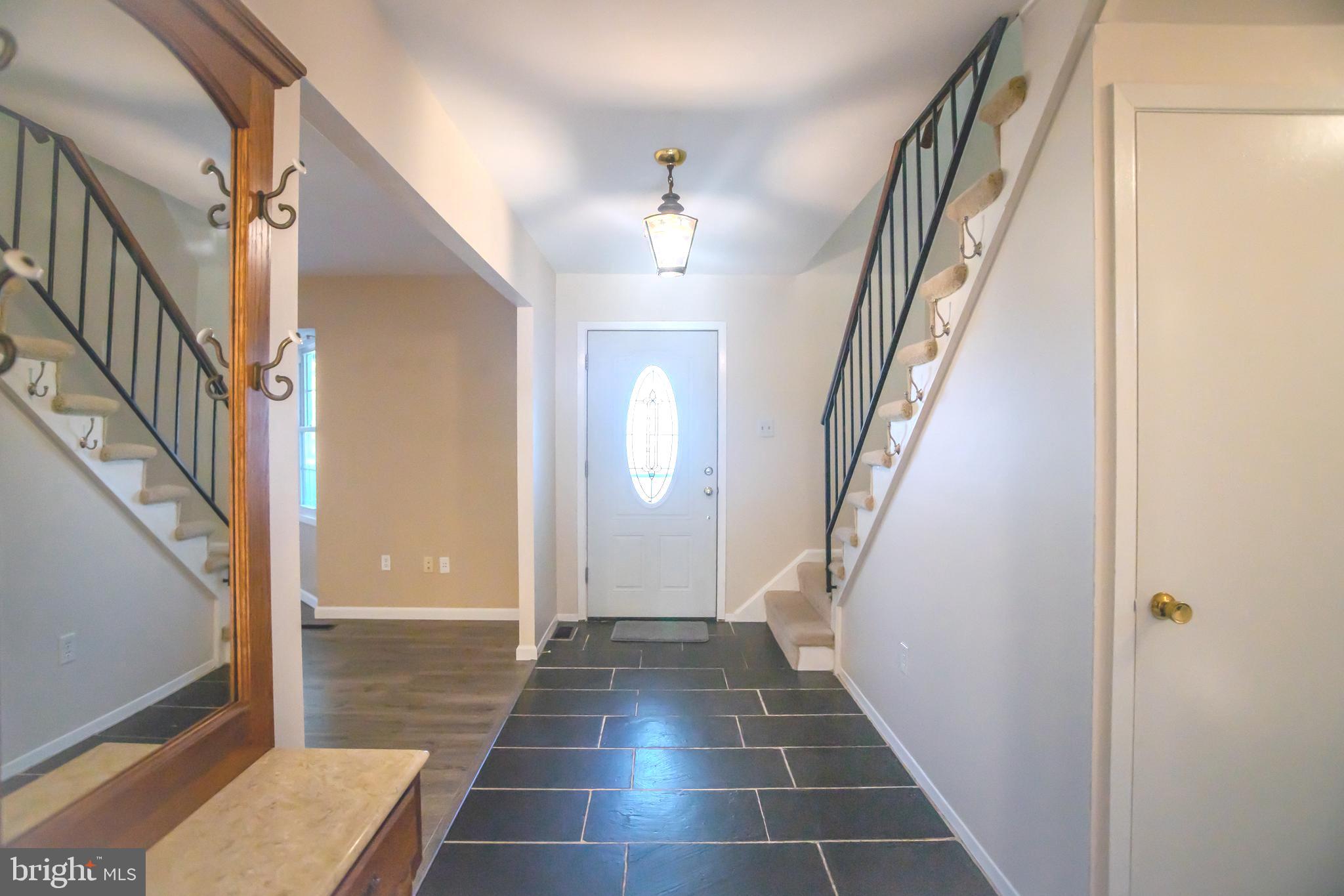 8815 Gramercy Lane Laurel, MD 20708 - Photo 15 of 42 a view of a hallway with wooden floor and staircase