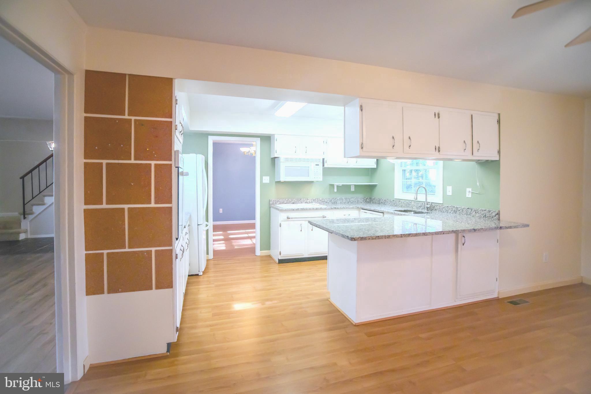 8815 Gramercy Lane Laurel, MD 20708 - Photo 8 of 42 a kitchen with stainless steel appliances granite countertop a stove a sink and a refrigerator