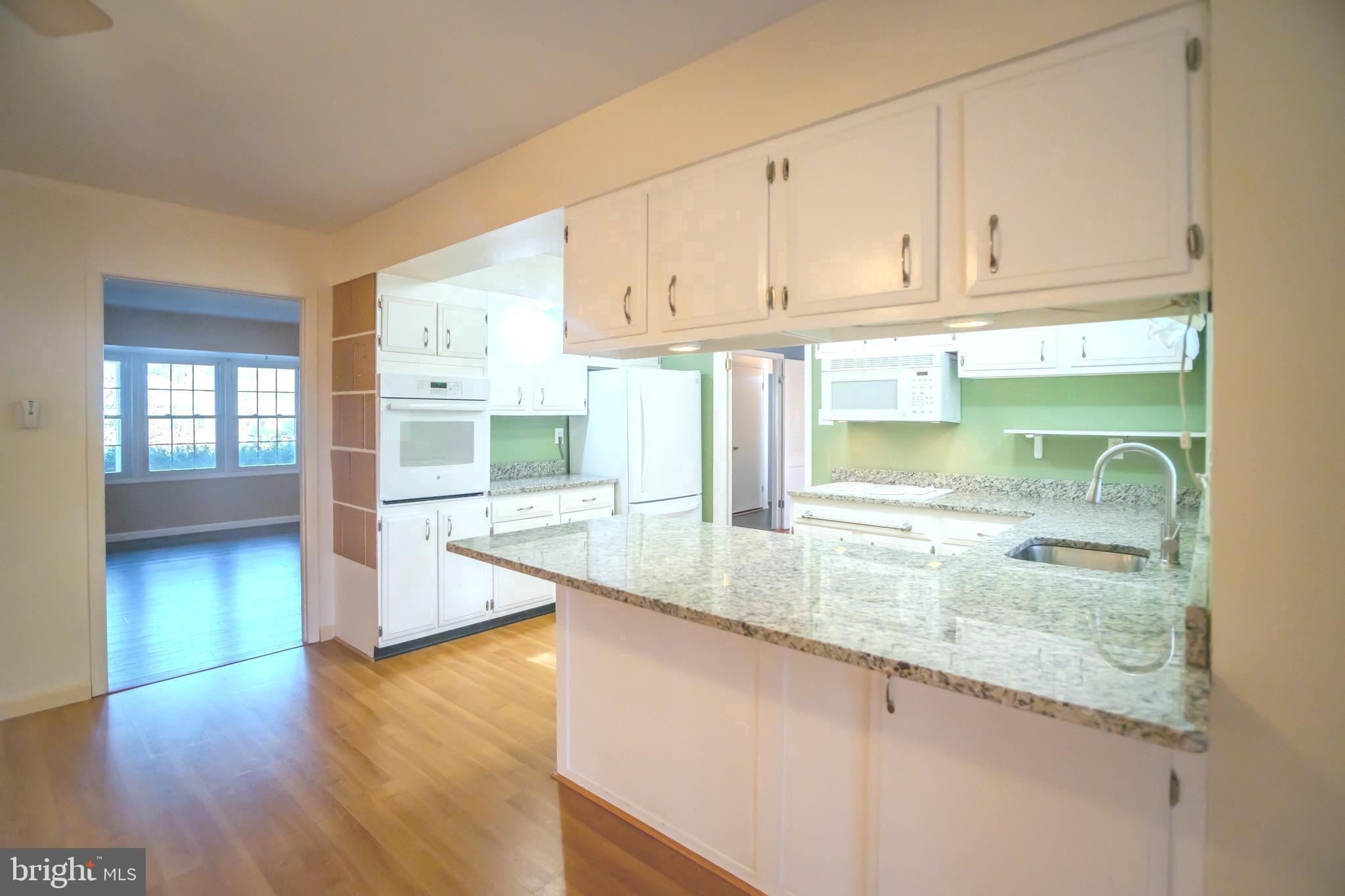 8815 Gramercy Lane Laurel, MD 20708 - Photo 9 of 42 a kitchen with stainless steel appliances granite countertop a sink and dishwasher with wooden floor
