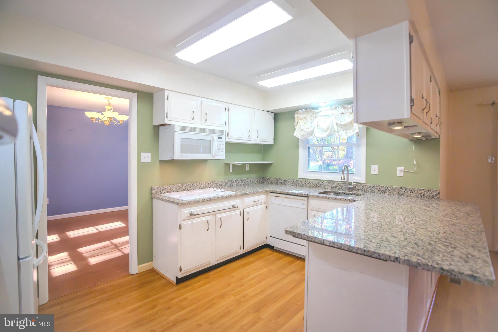 8815 Gramercy Lane Laurel, MD 20708 - Photo 10 of 42 a kitchen with granite countertop a sink a stove and cabinets