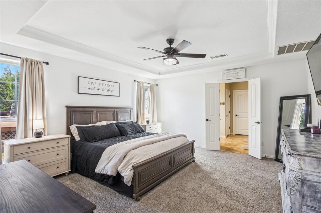 3390 Zion Hill Road Weatherford, TX 76088 - Photo 12 of 40 a bedroom with a bed and a chandelier