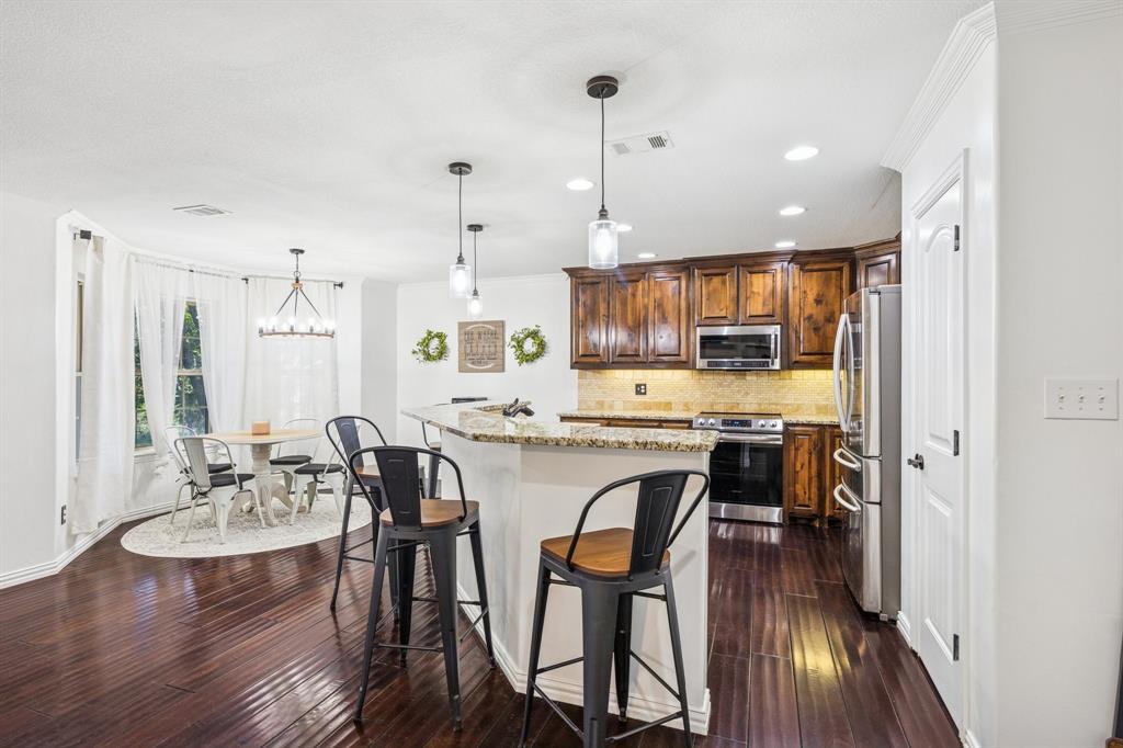 3390 Zion Hill Road Weatherford, TX 76088 - Photo 9 of 40 a view of a dining room and livingroom with furniture wooden floor a chandelier