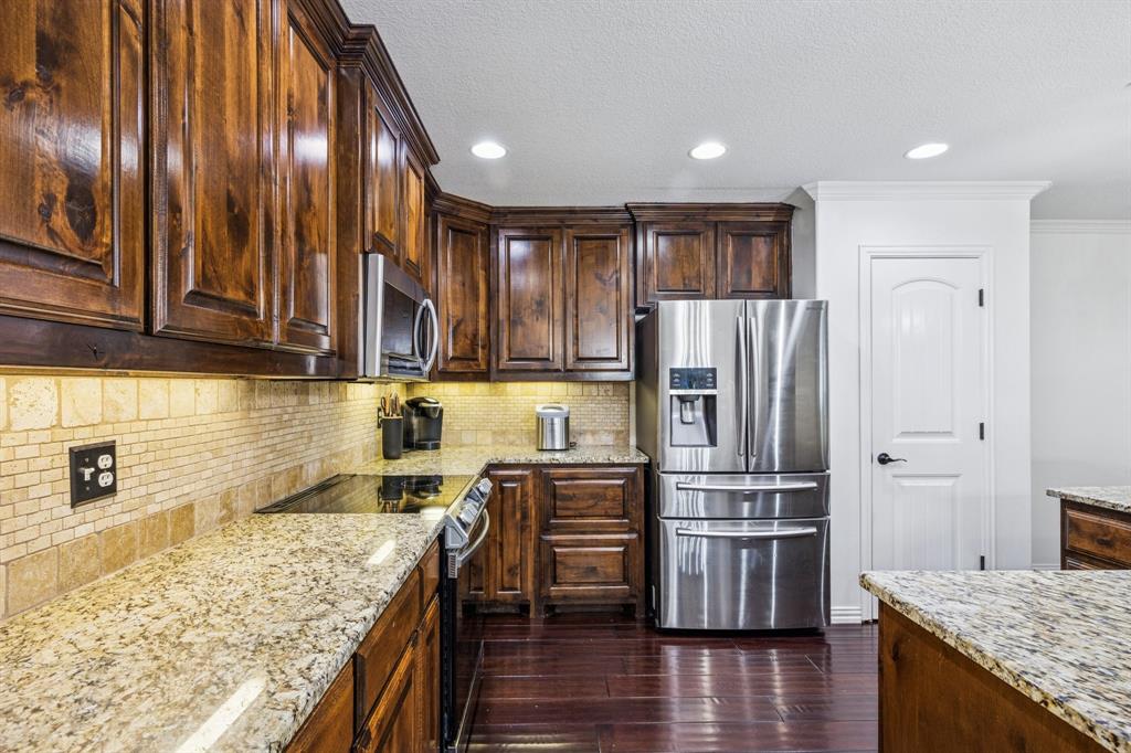 3390 Zion Hill Road Weatherford, TX 76088 - Photo 10 of 40 a kitchen with stainless steel appliances granite countertop a refrigerator and wooden cabinets