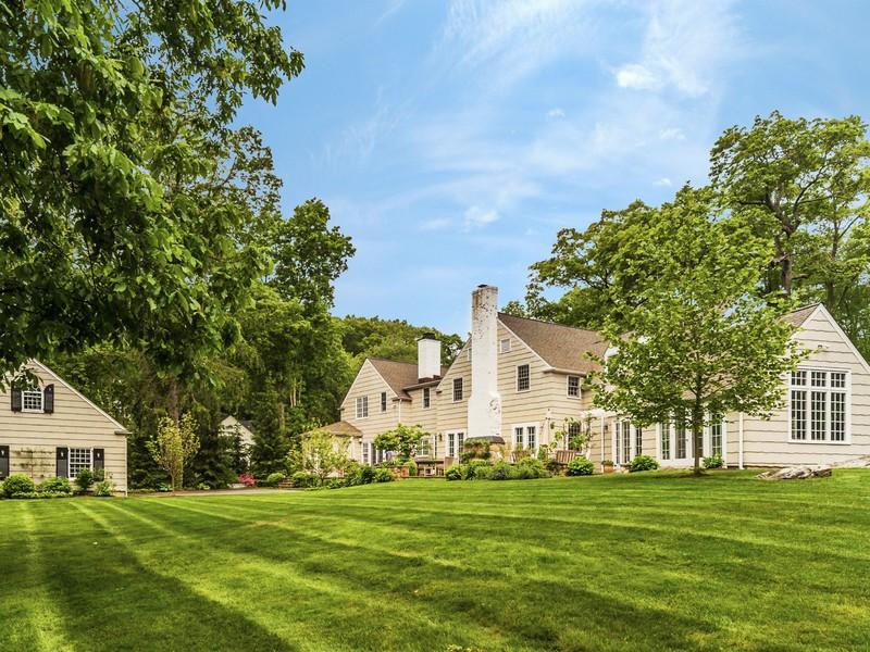 4 Point O Woods Road Darien, CT 06820 - Photo 23 of 23 a view of a white house in front of a big yard with plants and large trees