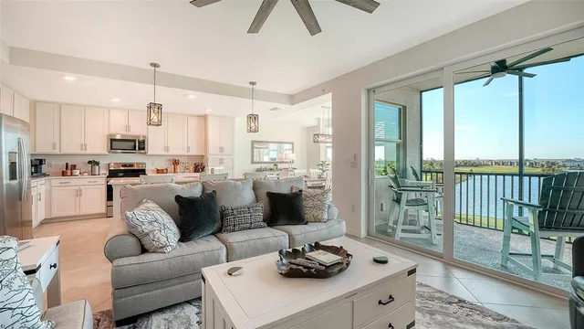 a kitchen with stainless steel appliances granite countertop a sink a stove a refrigerator cabinets and chairs