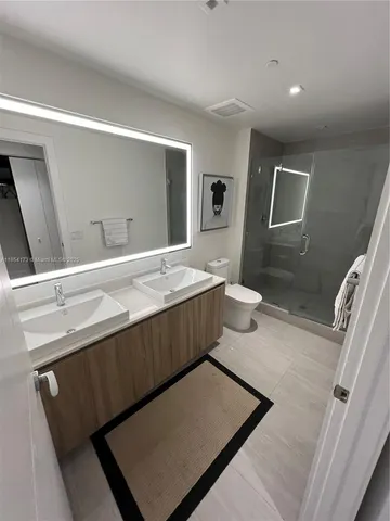 a bathroom with a sink a toilet and mirror