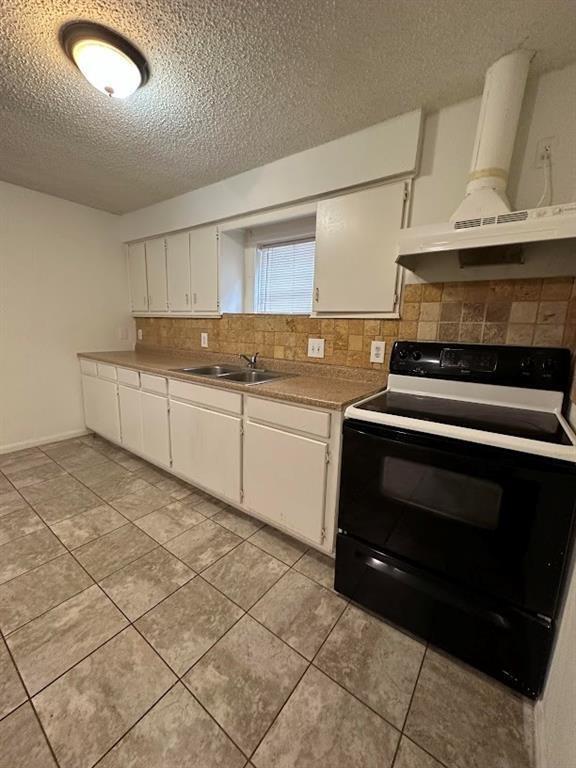 1148 1/2 Gunter Street, Unit A Austin, TX 78721 - Photo 9 of 10 a kitchen with granite countertop a stove and a sink