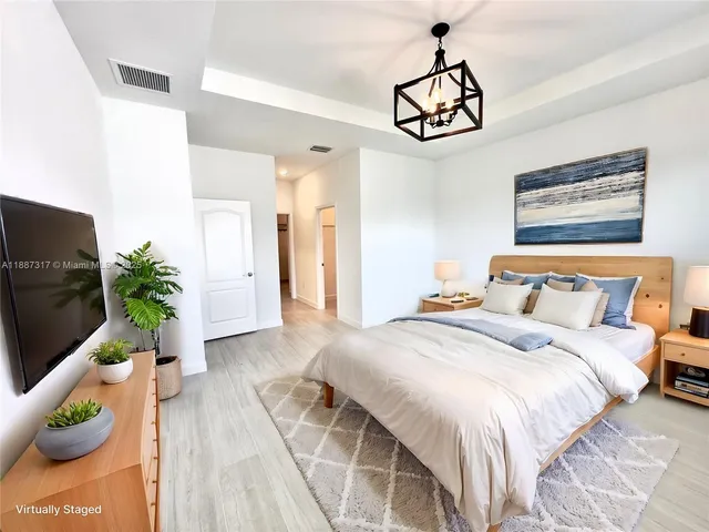 a bedroom with bed and a chandelier