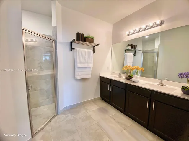 a spacious bathroom with a shower sink and mirror
