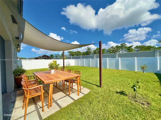 a view of a patio with a table chairs and a backyard